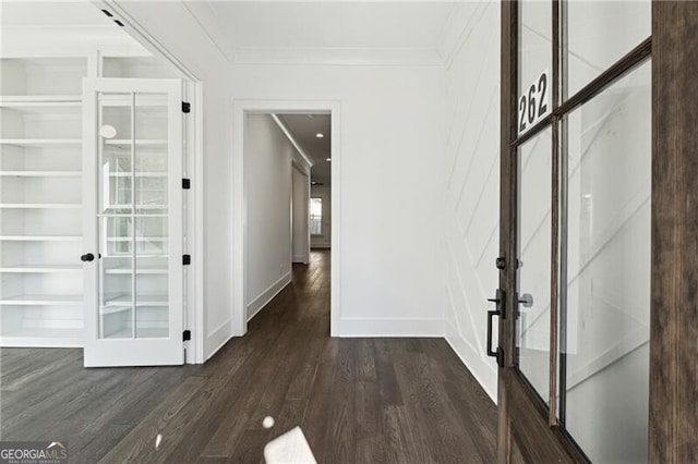 hallway featuring dark wood-style floors, baseboards, and ornamental molding