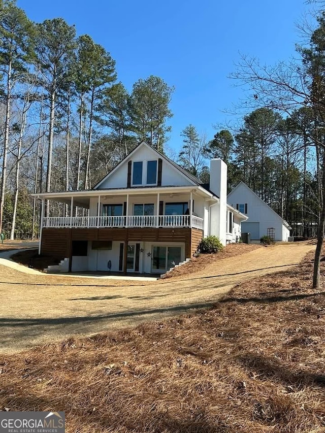 rear view of house with a deck and a chimney