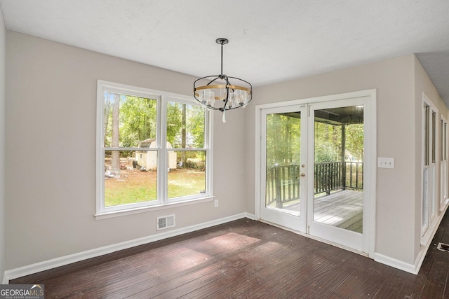 unfurnished dining area featuring a wealth of natural light, baseboards, and dark wood-style flooring