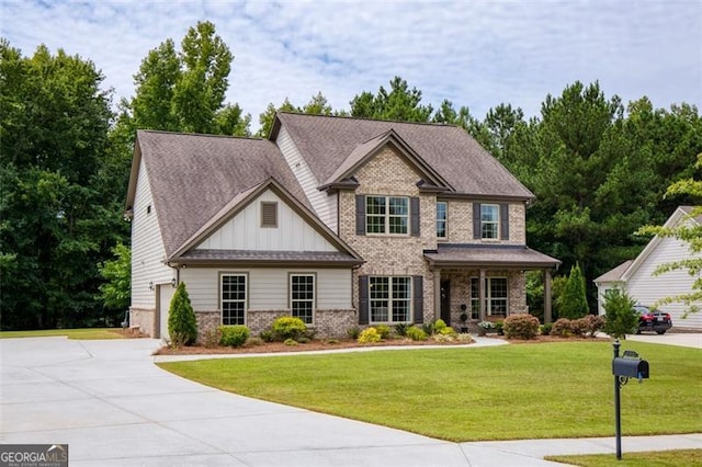 view of front facade with concrete driveway, a front lawn, a garage, board and batten siding, and brick siding