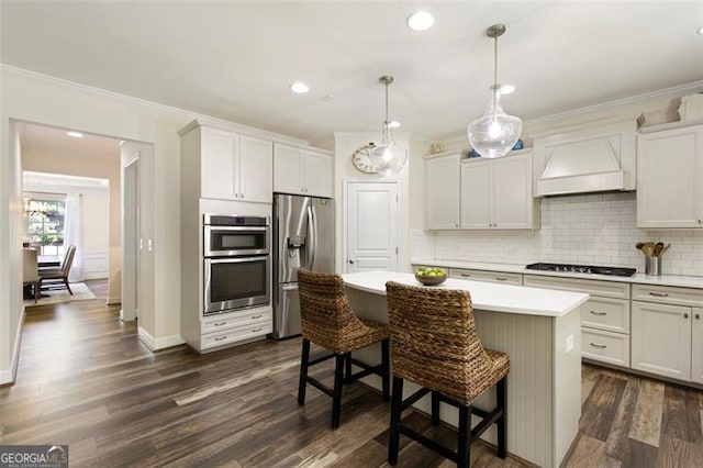 kitchen featuring light countertops, premium range hood, appliances with stainless steel finishes, and ornamental molding