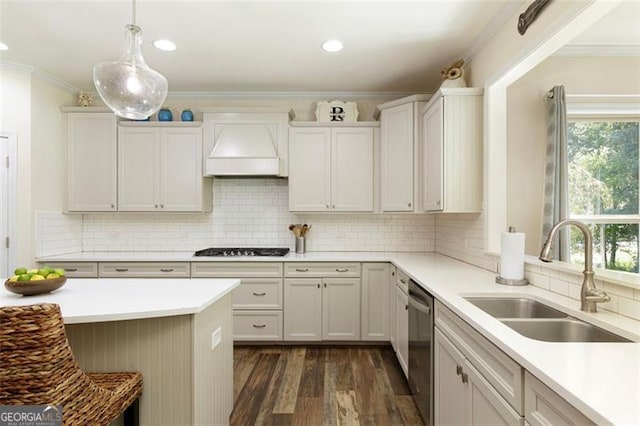 kitchen with premium range hood, a sink, gas cooktop, crown molding, and light countertops