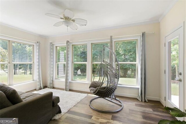 sunroom / solarium with a healthy amount of sunlight and ceiling fan