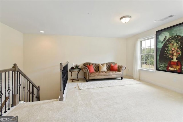 sitting room featuring visible vents, carpet floors, baseboards, recessed lighting, and an upstairs landing