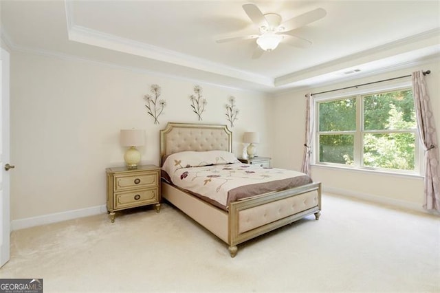 bedroom with a raised ceiling, ornamental molding, baseboards, and light carpet