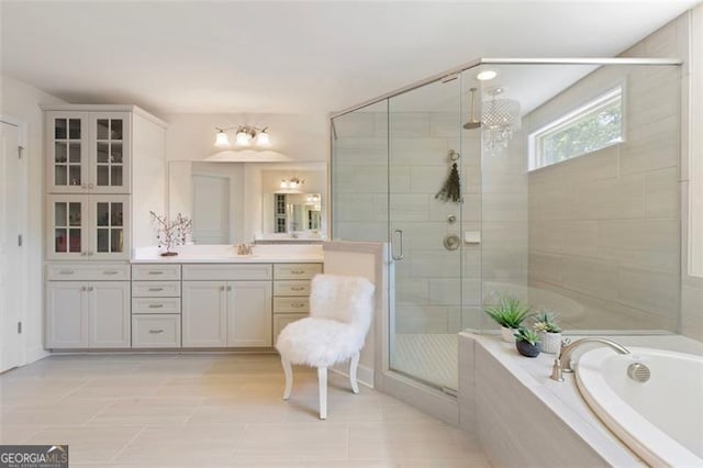 full bath featuring a bath, tile patterned flooring, a stall shower, and vanity