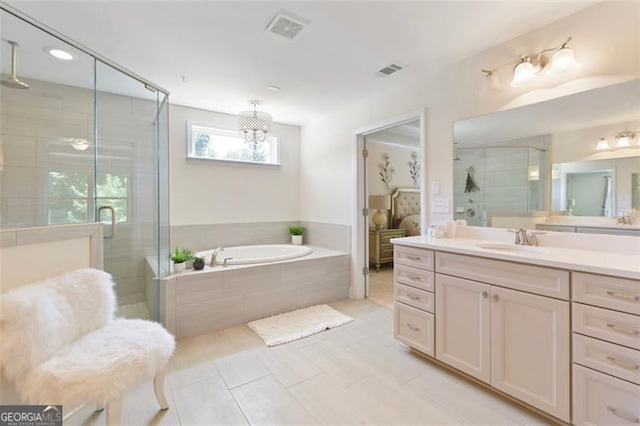 bathroom featuring a bath, visible vents, a shower stall, and vanity