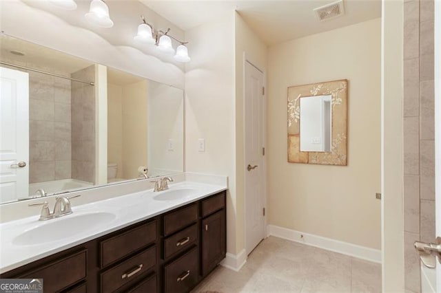 bathroom featuring double vanity, visible vents, baseboards, and a sink