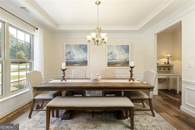 dining space featuring a wainscoted wall, wood finished floors, and a chandelier