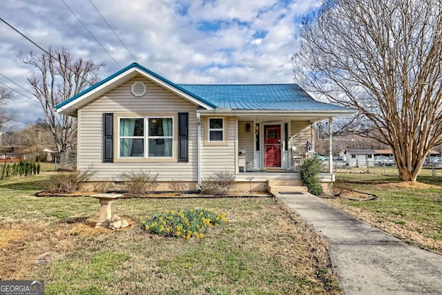 view of front of home featuring a porch, metal roof, and a front yard