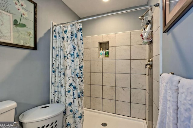 bathroom with a shower stall and toilet