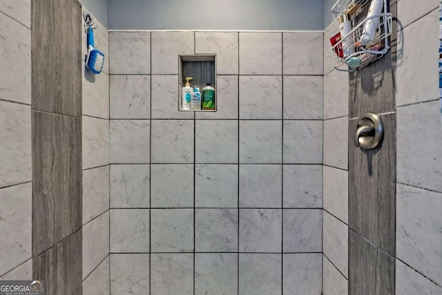 interior details featuring tiled shower