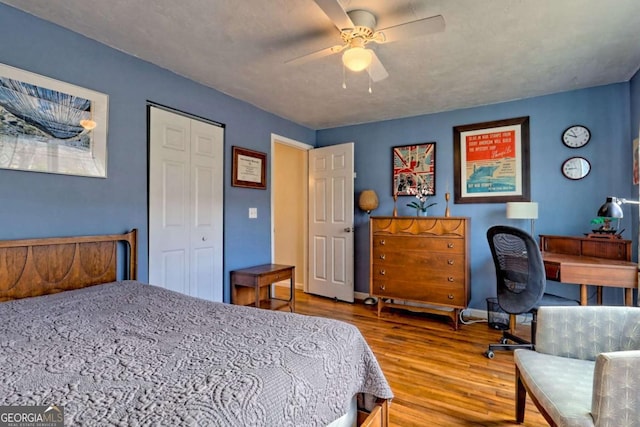 bedroom with ceiling fan, a closet, baseboards, and wood finished floors