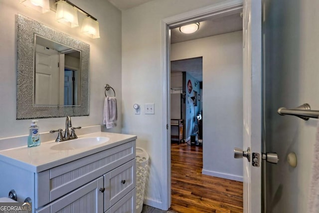 bathroom featuring vanity, baseboards, and wood finished floors