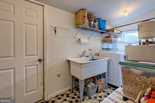 clothes washing area with washer and dryer, laundry area, and baseboards