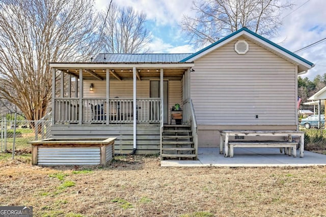 back of property featuring metal roof and a porch