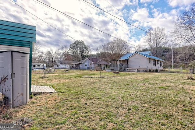 view of yard featuring a wooden deck, fence, and a residential view