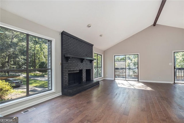 unfurnished living room featuring wood finished floors, visible vents, baseboards, a brick fireplace, and beam ceiling