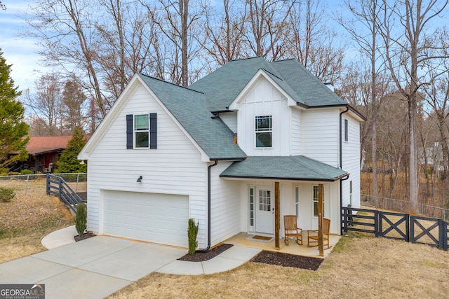 modern inspired farmhouse with a porch, a garage, fence, and board and batten siding