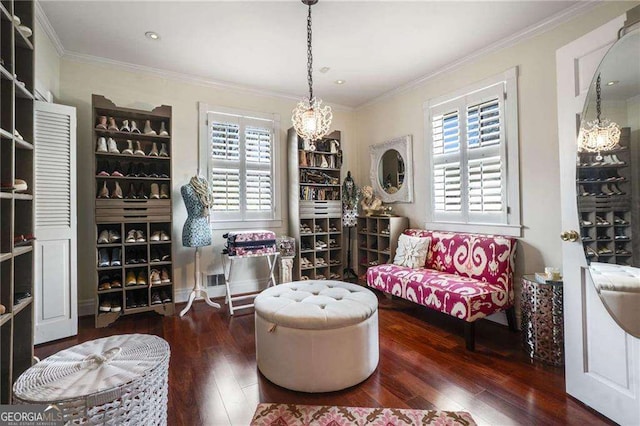 living area featuring crown molding, a chandelier, and hardwood / wood-style floors