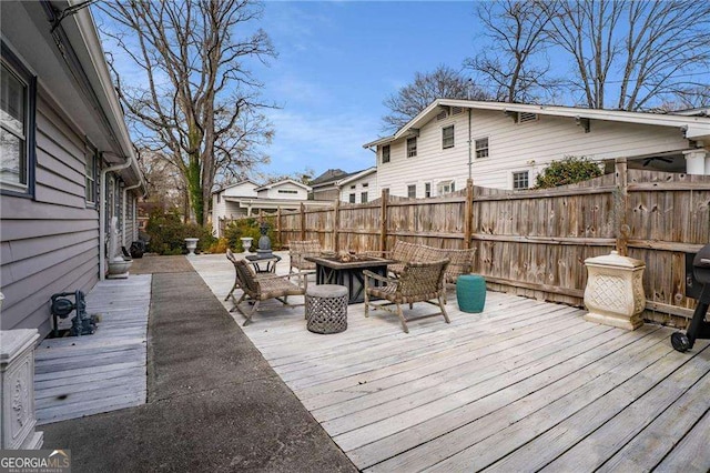 wooden deck featuring an outdoor fire pit and fence