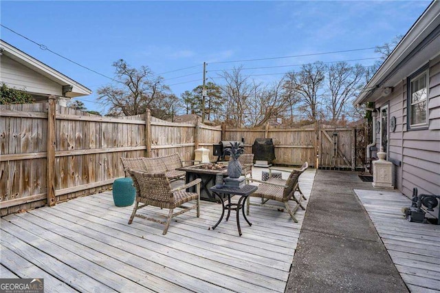 wooden terrace featuring a fire pit and fence