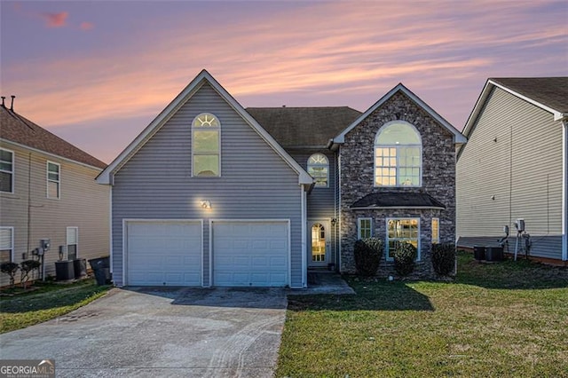 traditional-style home with an attached garage, cooling unit, concrete driveway, stone siding, and a front yard