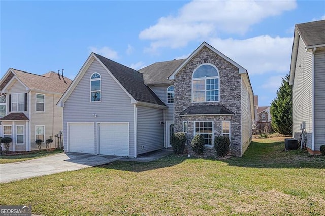 traditional-style home with concrete driveway, a front lawn, an attached garage, and stone siding