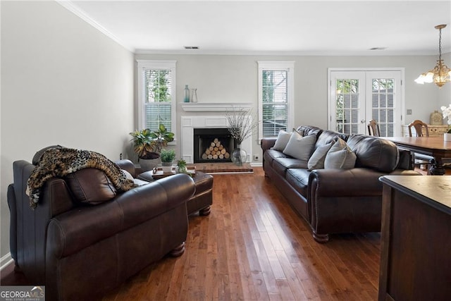 living room with dark wood-style floors, french doors, crown molding, and plenty of natural light