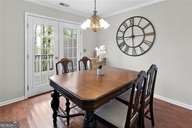 dining space with visible vents, crown molding, baseboards, and wood finished floors