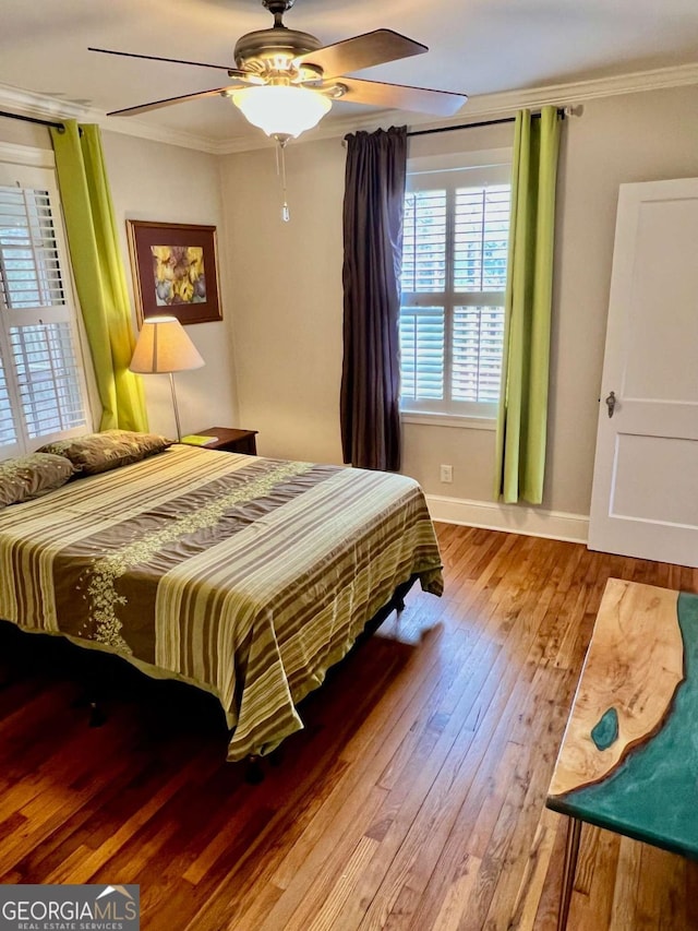 bedroom featuring light wood-style flooring, ornamental molding, ceiling fan, and baseboards