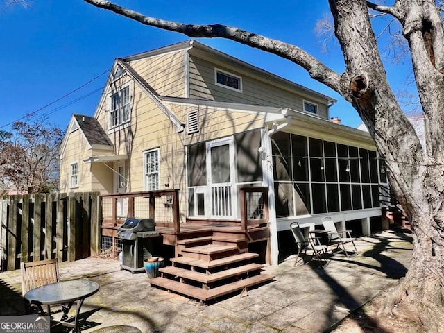 back of property featuring a sunroom, a patio area, and fence