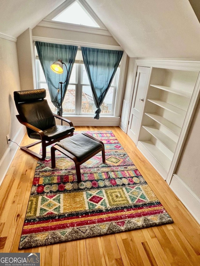 sitting room with lofted ceiling, wood finished floors, and baseboards