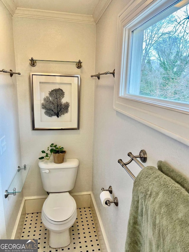 bathroom featuring ornamental molding, baseboards, and toilet