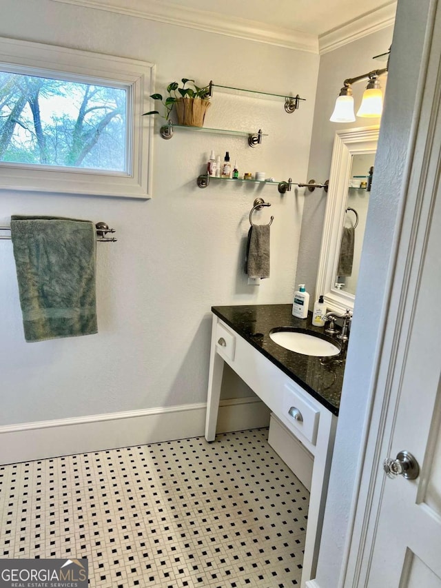 bathroom featuring baseboards, vanity, and crown molding