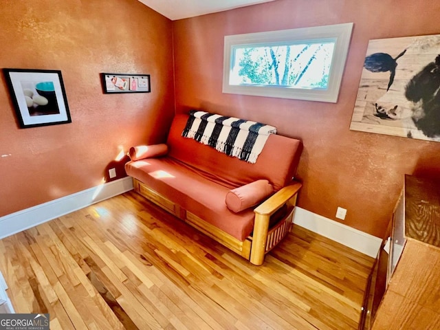 sitting room with baseboards and wood finished floors