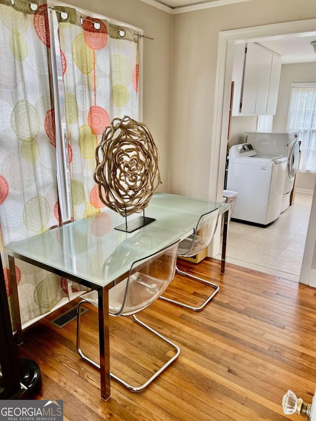 dining room with washing machine and dryer, visible vents, and light wood-style flooring