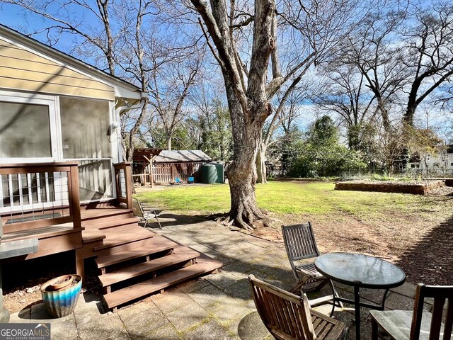 exterior space featuring a patio area, fence, and a sunroom