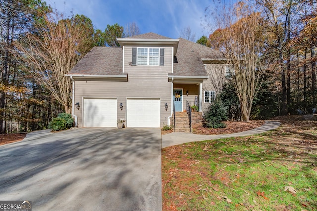 traditional home featuring an attached garage, driveway, and a shingled roof