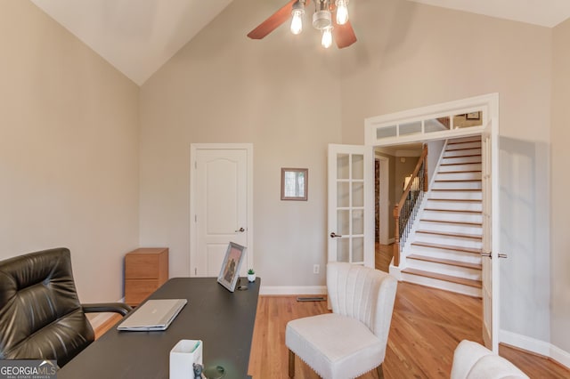 office space with high vaulted ceiling, a ceiling fan, wood finished floors, french doors, and baseboards