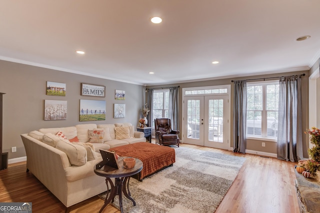 living room featuring french doors, crown molding, baseboards, and wood finished floors