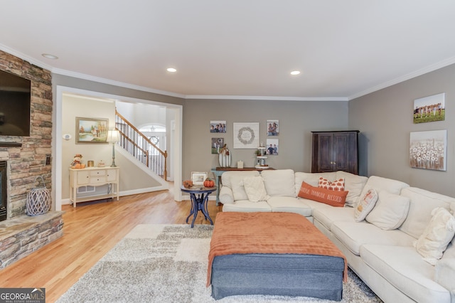 living area featuring ornamental molding, wood finished floors, recessed lighting, a fireplace, and stairs