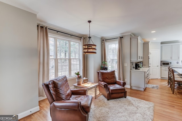 sitting room with crown molding, baseboards, a toaster, light wood-type flooring, and recessed lighting