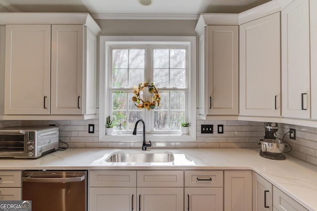 kitchen featuring ornamental molding, a sink, stainless steel dishwasher, white cabinetry, and decorative backsplash