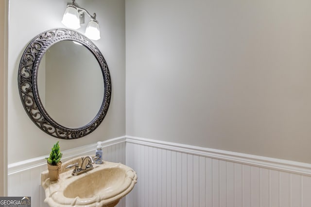 bathroom with a wainscoted wall and a sink