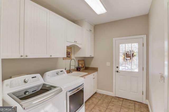 clothes washing area featuring light tile patterned floors, baseboards, cabinet space, a sink, and independent washer and dryer