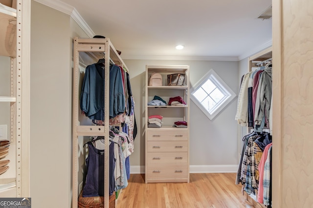 walk in closet with light wood-style floors