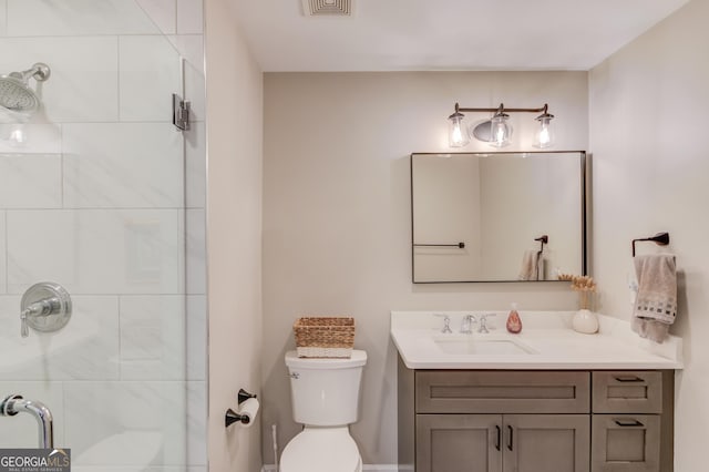 full bathroom featuring toilet, tiled shower, and vanity