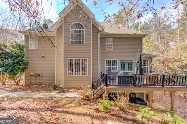 back of house featuring a wooden deck and stairs