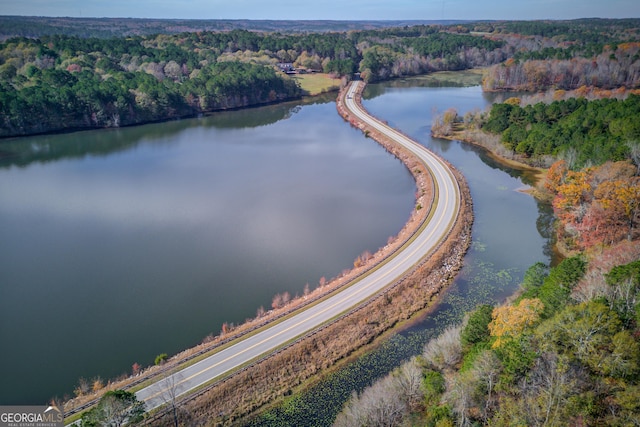 aerial view featuring a forest view and a water view